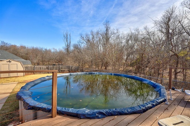 view of pool with a storage unit and a deck