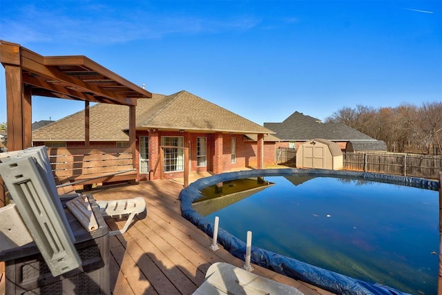 view of pool with a deck and a shed