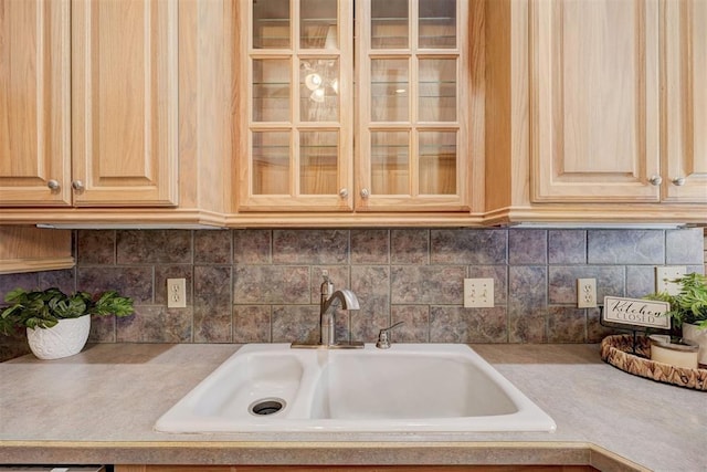 kitchen featuring light brown cabinetry, decorative backsplash, and sink