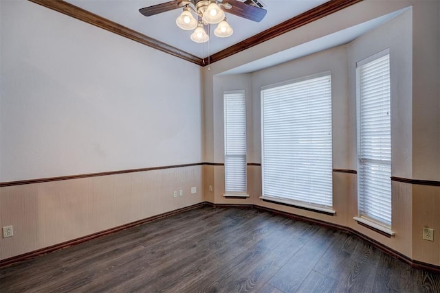 spare room featuring ceiling fan, a wealth of natural light, crown molding, and dark hardwood / wood-style floors