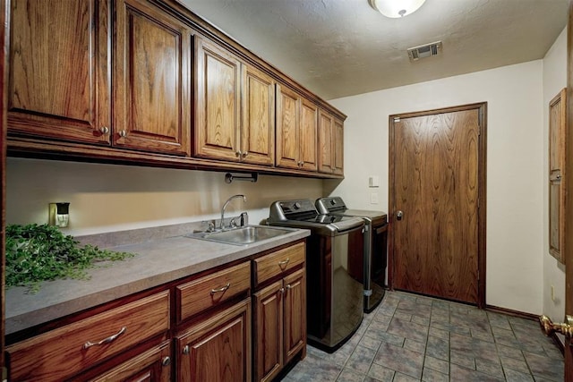 washroom with sink, separate washer and dryer, and cabinets