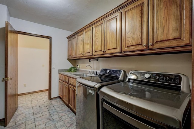 washroom featuring cabinets, sink, and washer and clothes dryer