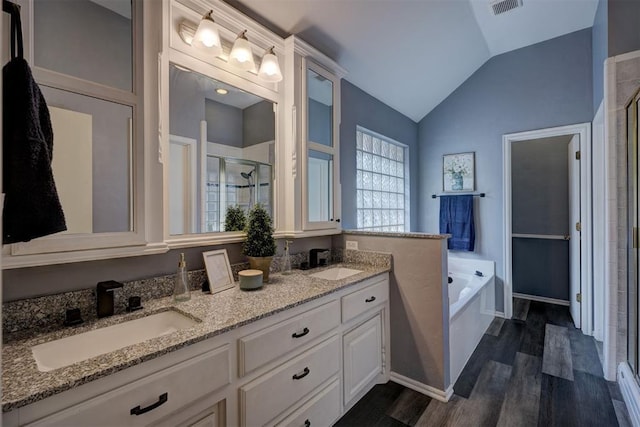 bathroom with lofted ceiling, vanity, shower with separate bathtub, and hardwood / wood-style floors