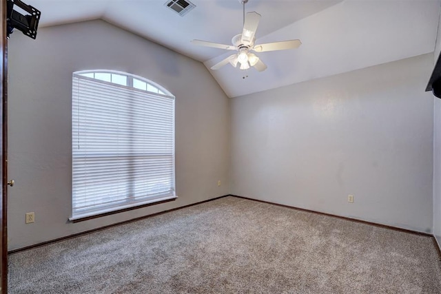 empty room featuring ceiling fan, vaulted ceiling, and light carpet