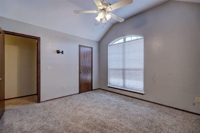 carpeted spare room with ceiling fan and lofted ceiling