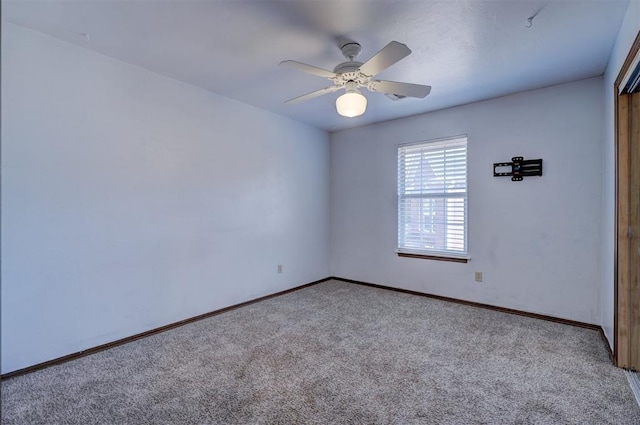 carpeted spare room with ceiling fan