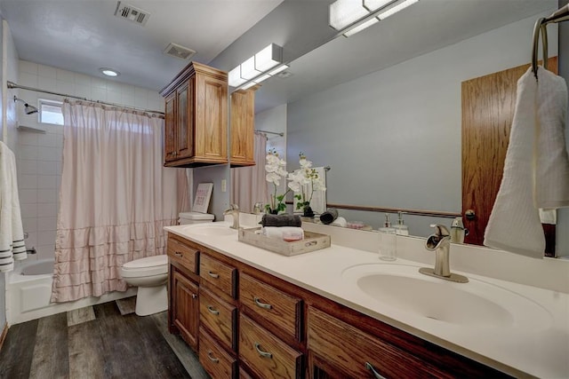 full bathroom with shower / bath combo with shower curtain, hardwood / wood-style floors, toilet, and vanity