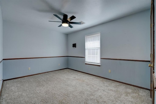 carpeted spare room featuring ceiling fan