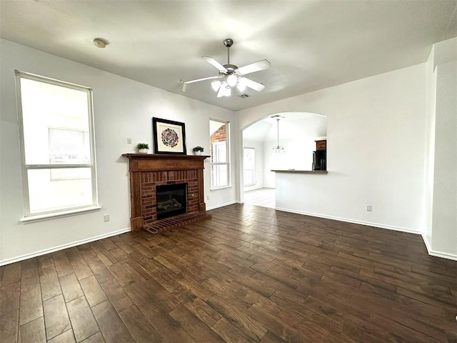 unfurnished living room with dark hardwood / wood-style floors, ceiling fan, and a fireplace