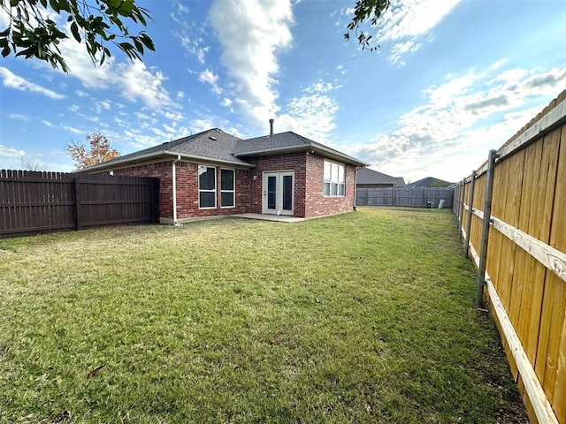 rear view of house with a lawn and french doors