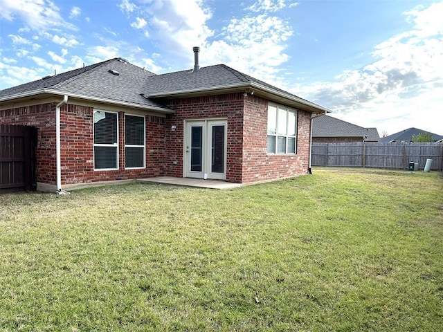 back of house with a patio and a lawn