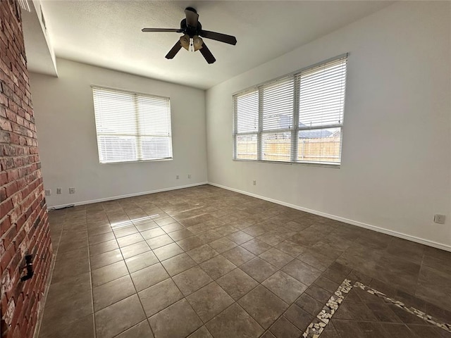 tiled empty room with ceiling fan and plenty of natural light