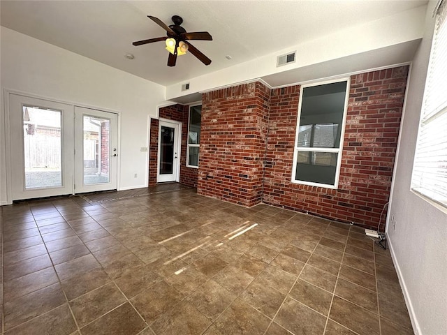 interior space with ceiling fan and brick wall