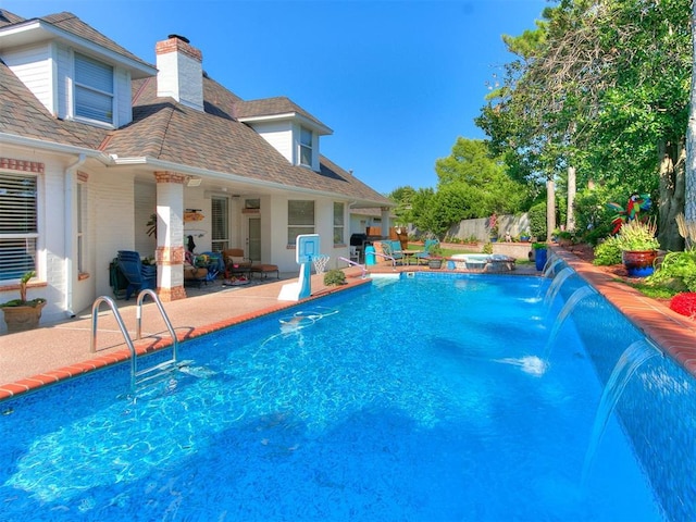 view of swimming pool with pool water feature, a patio, and a hot tub