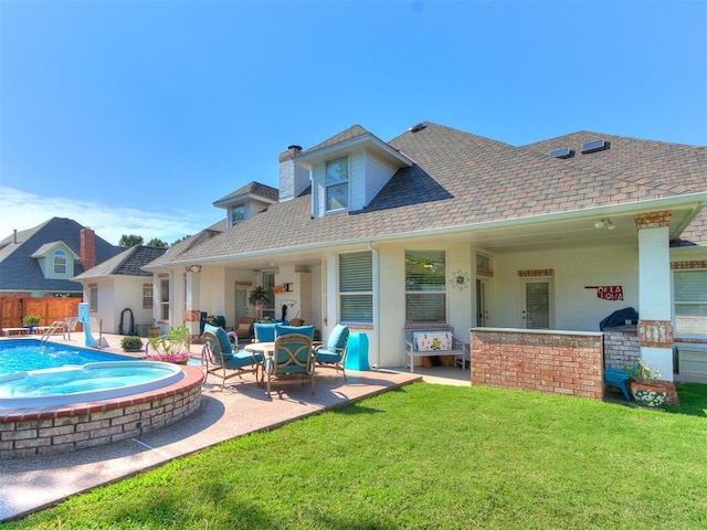 rear view of house with a yard and a patio