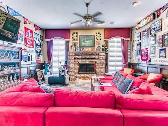 living room featuring a fireplace and ceiling fan