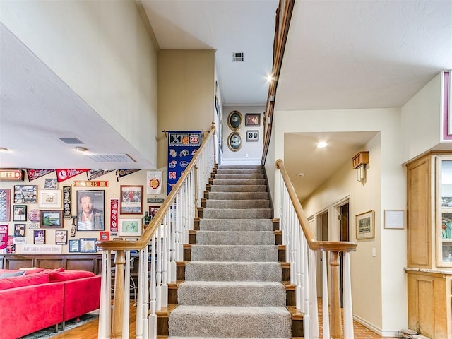 stairway with hardwood / wood-style flooring and crown molding