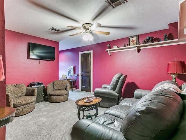 living room with carpet flooring, ceiling fan, and a textured ceiling