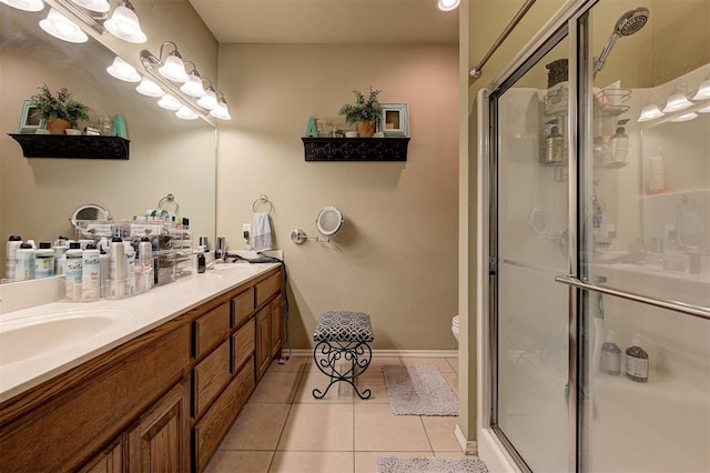 bathroom with tile patterned floors, vanity, toilet, and an enclosed shower