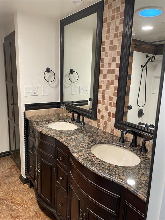 bathroom with a sink and double vanity