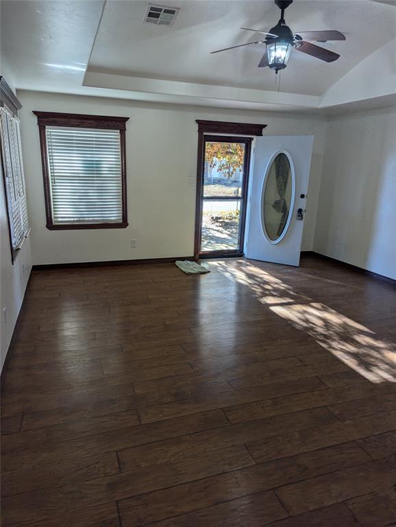 entrance foyer with a tray ceiling, visible vents, dark wood finished floors, and ceiling fan