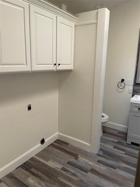 clothes washing area featuring baseboards, dark wood finished floors, and hookup for an electric dryer