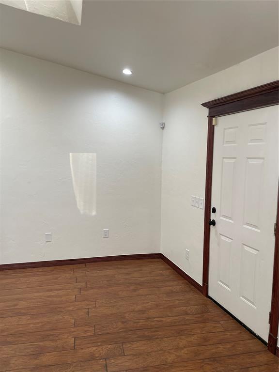 spare room featuring dark wood-style floors, recessed lighting, and baseboards