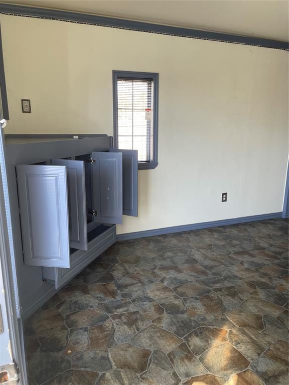 spare room with stone finish floor and baseboards