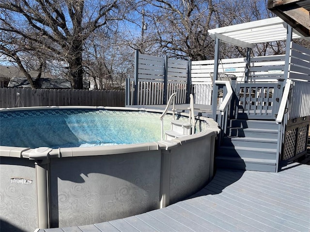 view of pool featuring a pergola, a wooden deck, a fenced in pool, and fence