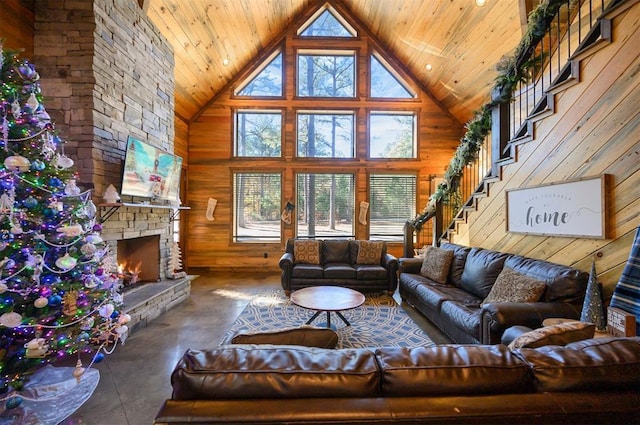 living room with wood walls, a stone fireplace, and high vaulted ceiling