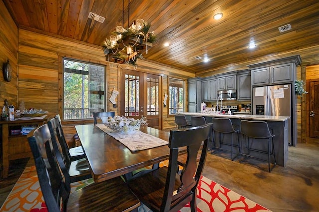 dining room with wood walls and wood ceiling