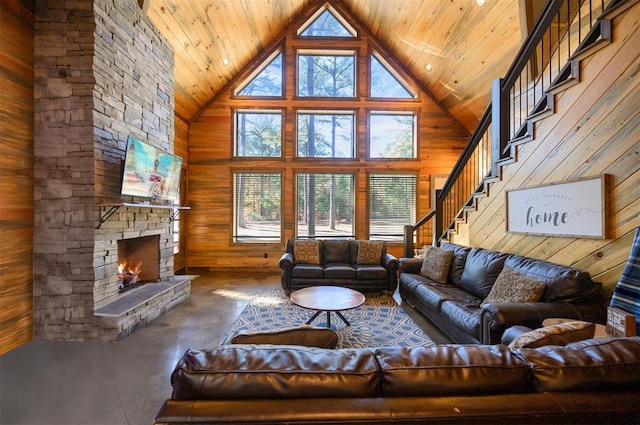 607 Sugar Pine Loop, Broken Bow, OK 74728 - living room featuring high vaulted ceiling, wooden walls, a fireplace, stairs, and wood ceiling