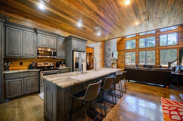607 Sugar Pine Loop, Broken Bow, OK 74728 - kitchen with appliances with stainless steel finishes, wood ceiling, wooden walls, finished concrete floors, and open floor plan