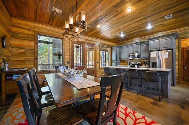 607 Sugar Pine Loop, Broken Bow, OK 74728 - dining room with wood ceiling, wooden walls, a chandelier, concrete floors, and recessed lighting