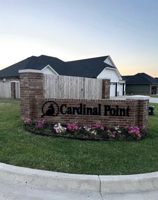 community sign featuring a garage and a yard