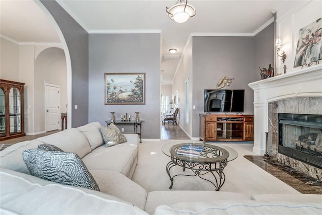 living room featuring crown molding and a tiled fireplace