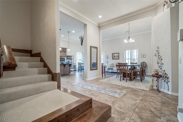 interior space with a notable chandelier, a towering ceiling, and crown molding