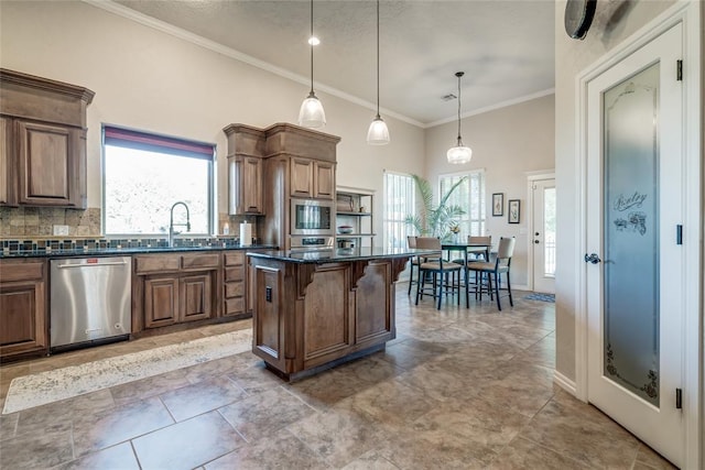 kitchen with a wealth of natural light, a breakfast bar, a kitchen island, and stainless steel appliances