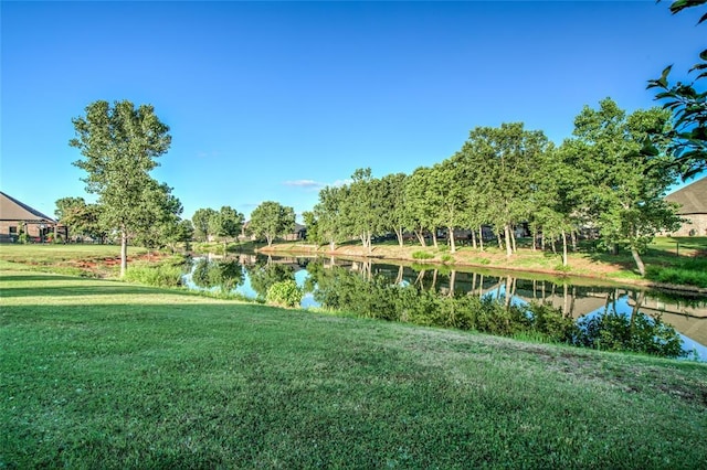 view of property's community with a yard and a water view