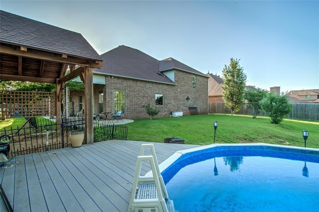 view of swimming pool featuring a deck and a lawn