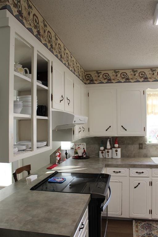 kitchen with white cabinets, a textured ceiling, and black range oven