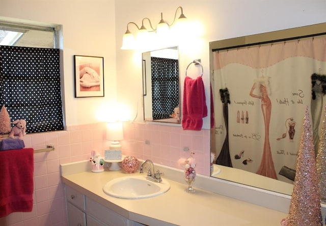 bathroom with a shower with curtain, vanity, and tile walls