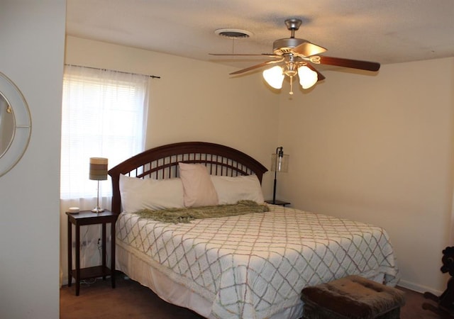 bedroom with dark colored carpet and ceiling fan