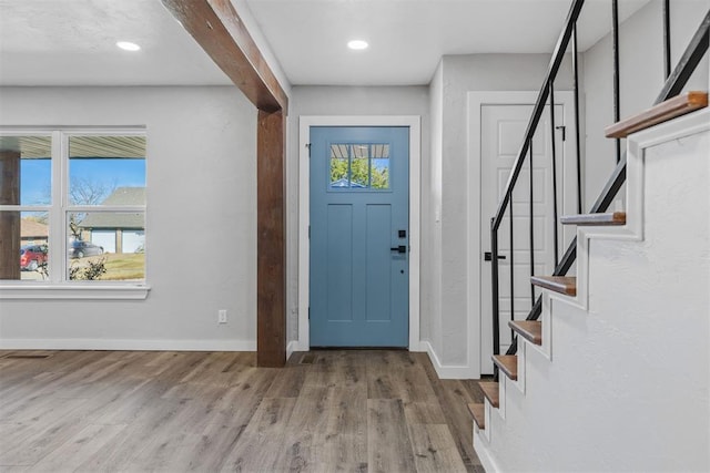 entryway featuring beamed ceiling, plenty of natural light, and light hardwood / wood-style floors