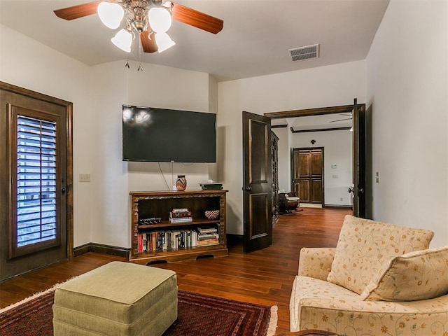 living room featuring dark wood-type flooring and ceiling fan