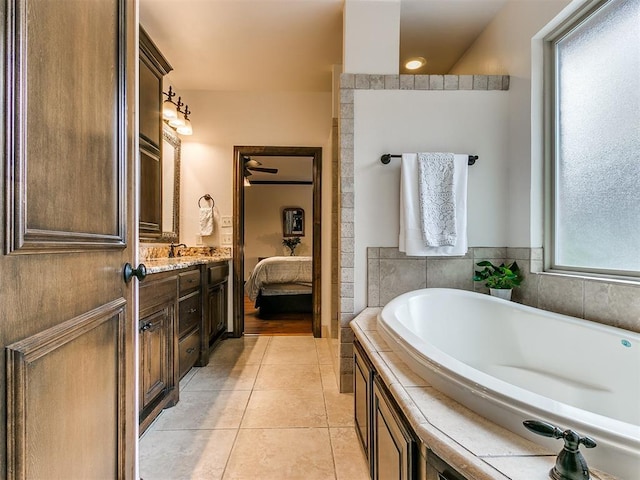 bathroom with vanity, tile patterned floors, and a tub to relax in