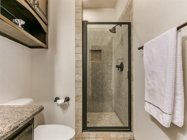 bathroom featuring vanity, toilet, and an enclosed shower