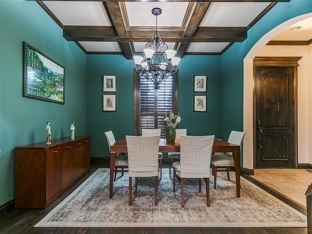 dining space with hardwood / wood-style floors, a chandelier, coffered ceiling, crown molding, and beam ceiling