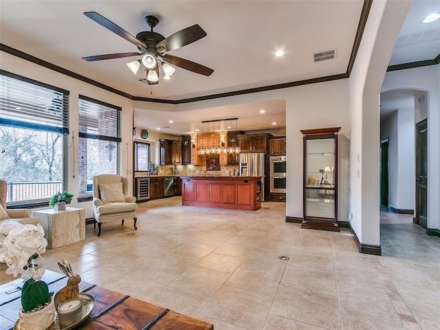 living room with crown molding, a healthy amount of sunlight, and beverage cooler