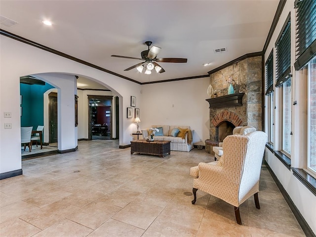 living room featuring a fireplace, ornamental molding, and ceiling fan